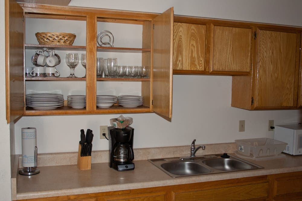 Kitchen stocked with dishes, glassware and coffee maker