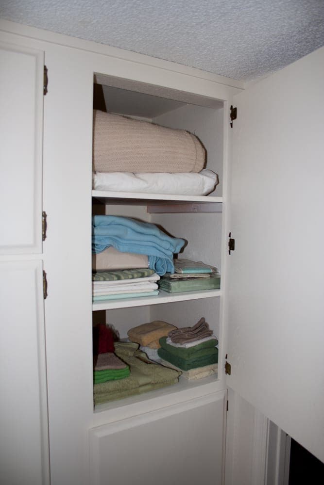 Linen closet stocked with towels and bedding